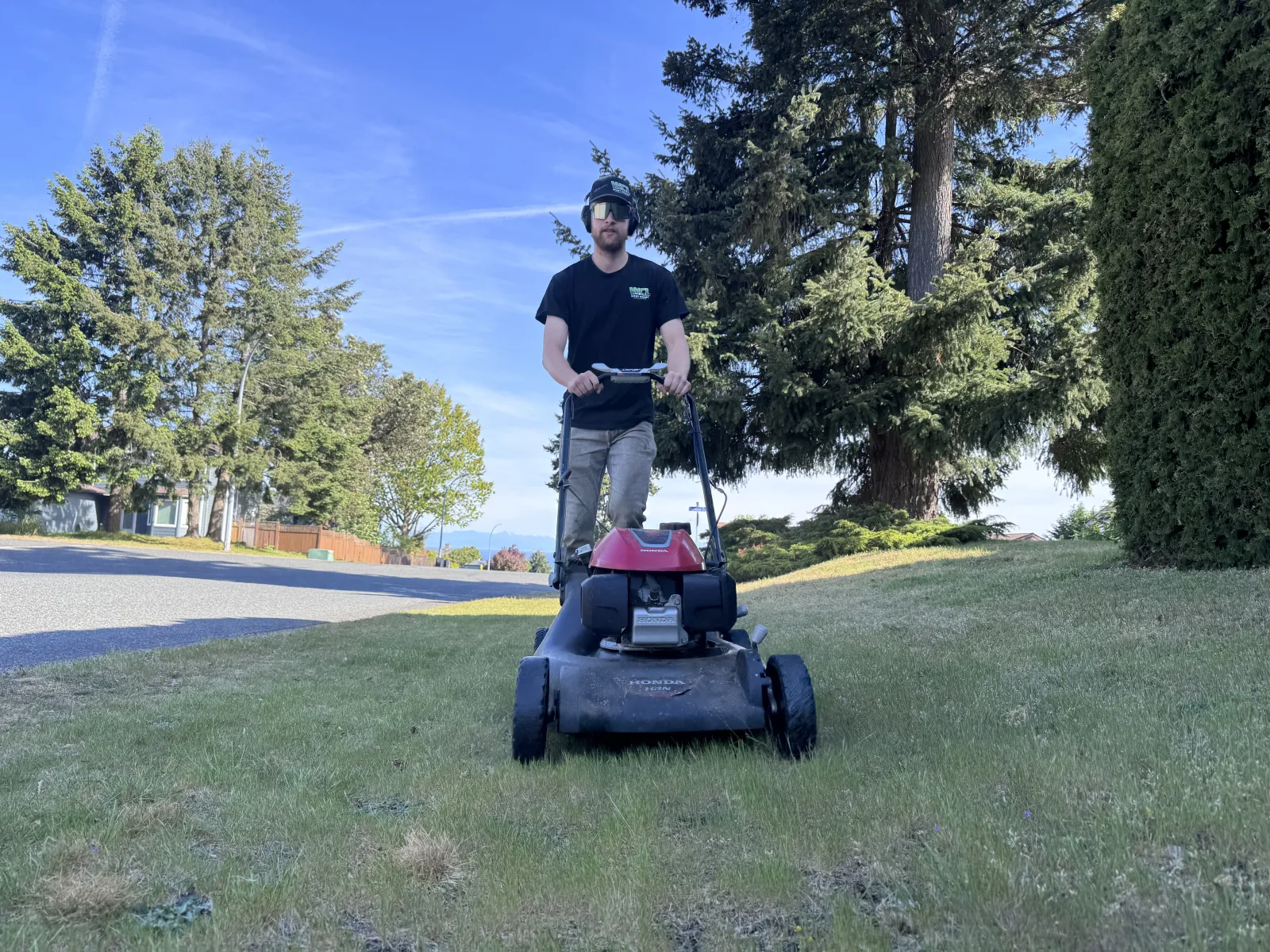 Matthew Hutchison mowing a Nanaimo lawn for West Coast Landscaping
